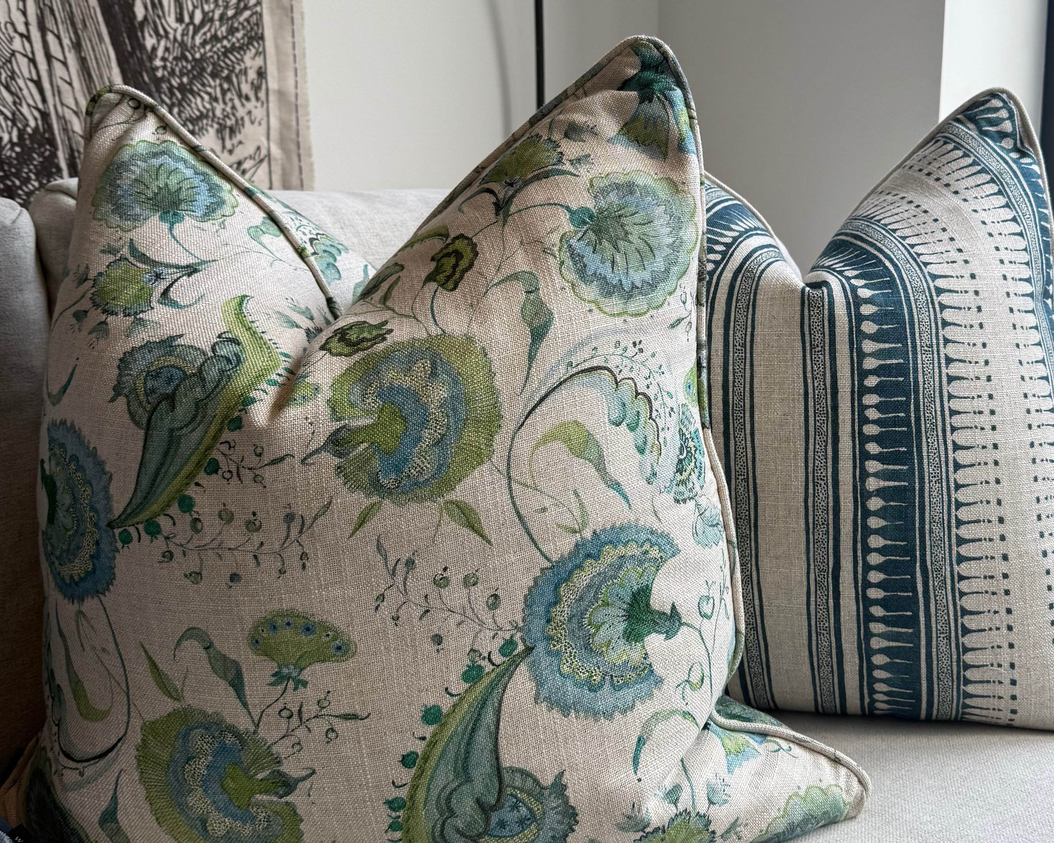 Decorative pillows on a sofa with a floral pattern and striped design.